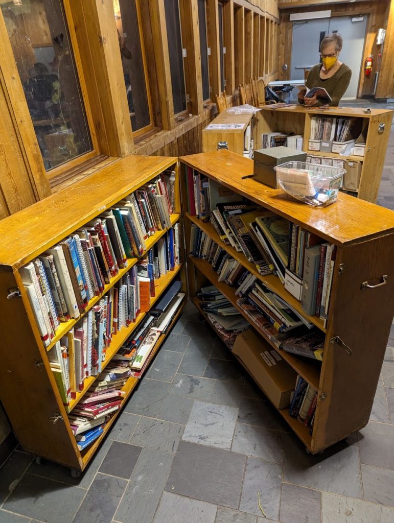 One of our members browses the collection at a recent meeting. Both folding shelf cabinets are open to display the books and magazines in our physical resource library.